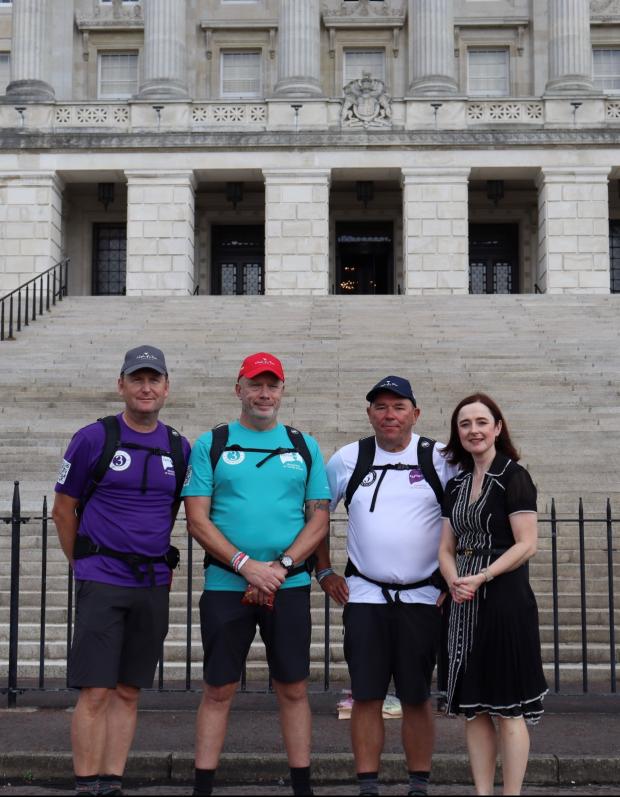 Professor Siobhan O'Neill and the 3 Dads standing in front of Stormont